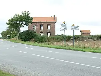 Vue de l'ancien bâtiment voyageurs et de son annexe sanitaire, très délabrés.