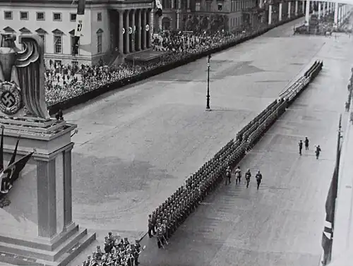 Mussolini passe en revue un bataillon d’honneur devant le monument aux Morts de la guerre sur la célèbre avenue Unter den Linden décorée et complètement dégagée, lors de sa visite à Berlin.
