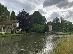Rivière de l'Ourcq canalisée. A gauche, un ancien grenier à grain. Puis la passerelle Eiffel, une tour des fortifications et le Mail.