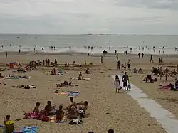 Vue en couleur d'une plage et de baigneurs.