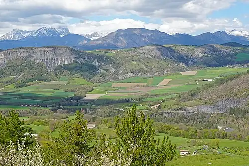 La vallée de l'Avance (au milieu) qui traverse le dome de Remollon rejoint la vallée de la Durance. En arrière plan à gauche le pic de Bure enneigé puis plus à droite la montagne de Charance.