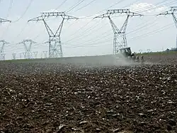 Vue d’un tracteur labourant des champs.