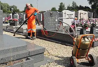 Employé communal effectuant le désherbage thermique.