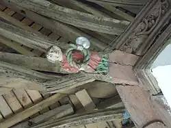 Blochet sculpté : Buste d'angelot tenant une couronne d'épines.