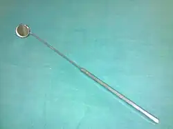 photo d'un miroir circulaire monté sur un manche métallique droit