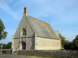 Vue d’une chapelle aux murs de granit et toit en ardoises.