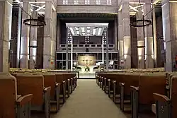 L'autel et son dais métallique vu depuis les bancs de fidèles.