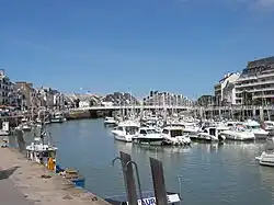 Vue en couleur d'un port de plaisance peuplé de voiliers.