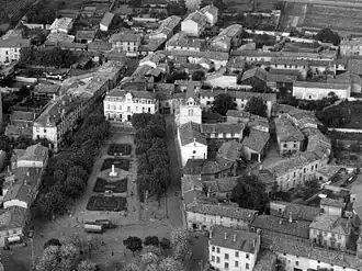 Le bourg de Vénissieux vu du ciel dans les années 1950. On aperçoit la rue du Château entourant l'église Saint-Germain.