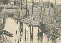 Extrait d'une ancienne carte postale en noir et blanc figurant une rivière et les paysages qui l'environnent.