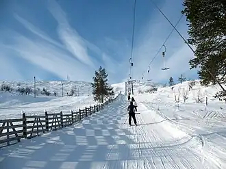 Vue d'une remontée mécanique sur la montagne avec le sommet en arrière-plan à gauche.