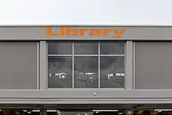Bâtiment vitré sur la façade duquel est écrit « Library ».