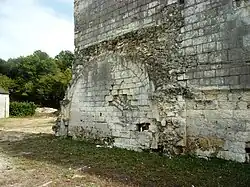 Photographie en couleurs d'un mur sur lequel est plaqué un grand arc brisé.