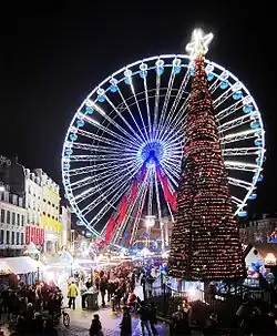 Photo de la grande roue de Noël avec en arrière-plan, la colonne de la Déesse.