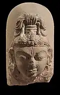 Linga à visage divin : le troisième œil sur le front symbolise l'omniscience de Shiva. VIIIe – IXe&nbsp;siècle. Calcaire, H. 25&nbsp;cm. Inde du Nord