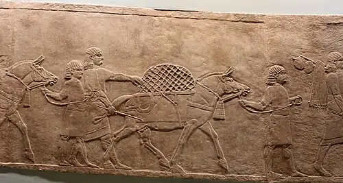 Serviteurs et ânes portant l'équipement nécessaire à la chasse, dont des filets.