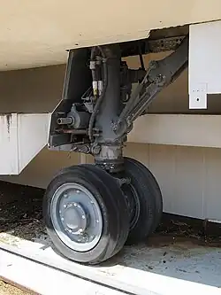 Photographie d'un train d'atterrissage avant d'un avion au sol.