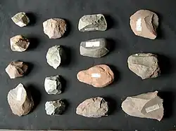 Stone tool artifacts include flakes, cores, and hammers used by hominins during the Paleolithic Period