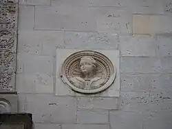 Photographie en couleur d'un détail sculpté sur la façade d'un bâtiment.