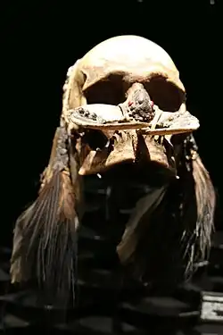 Crâne-trophée Asmat.  Os, graines, coquillages, plumes, fibres. H. 30&nbsp;cm. Irian Jaya. Indonésie.1850-1950