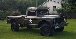 Le M 715 a deux places à l'avant et une benne à l'arrière. Cet exemplaire a une peinture marron, une étoile blanche sur la porte et l'inscription U.S. Army 3A5356 sur le capot et 196BG et HQ-4 sur le pare-choc avant.