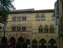 photo couleur de façades de maison en pierre à fenêtres géminées en ogive.