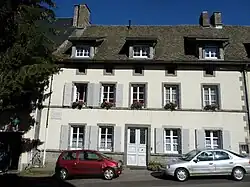 Maison blanche dans l'alignement des autres. Deux fenêtres de part et d'autre de la porte d'entrée, cinq au 1er&nbsp;étage, trois s'ouvrant dans le toit sur des chambres mansardées