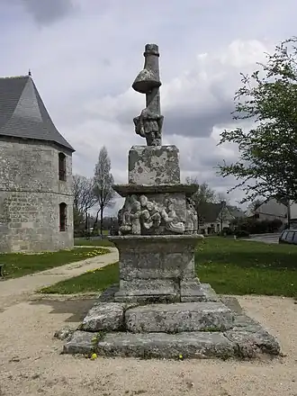 Croix de Malguénac en France avec notamment un socle aux 4 faces ornées d'une frise de sculptures grossières représentant des scènes de la Passion).