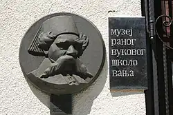 Plaque avec le visage de Vuk Stefanović Karadžić à l'entrée du musée commémoratif.