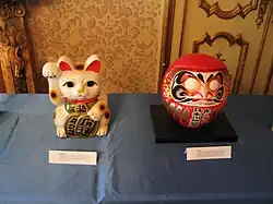 Un maneki-neko avec une autre figurine porte-bonheur : le daruma.