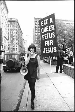 Chris Korda s'exprime dans un mégaphone lors d'une manifestation de l'Église de l'Euthanasie