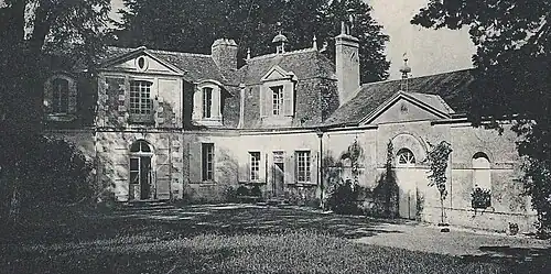 Photographie en noir et blanc de la façade d'un manoir muni d'une aile en retour d'équerre.