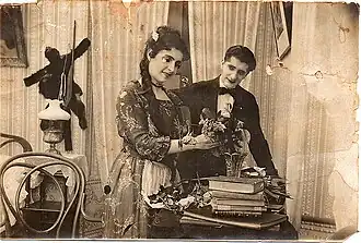 Photo en noir et blanc montrant une femme recevant des fleurs, un homme à ses côtés lui sourit