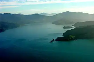 Photographie aérienne à basse altitude d'une baie vue en direction de l'amont.