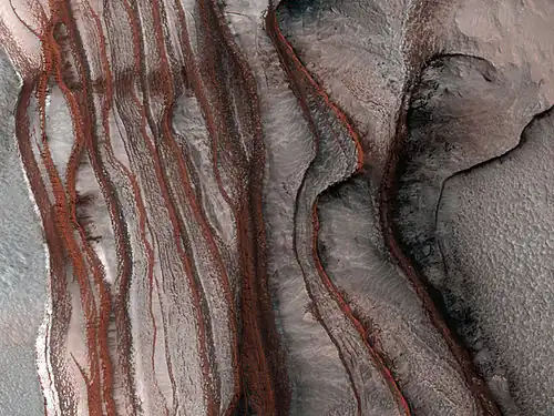 Strates sur les pentes de Chasma Boreale, vallée qui s'enfonce dans la calotte polaire. L'image fait 1&nbsp;km de droite à gauche et la dénivelée est également de 1&nbsp;km.
