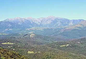 Le flanc est du massif du Canigou (au loin, jusqu'à plus de 2 500 mètres altitude) domine le massif des Aspres (au premier plan, moins de 1 500 mètres).