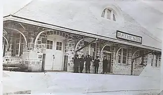 photo noir et blanc du bâtiment, avec personnages.
