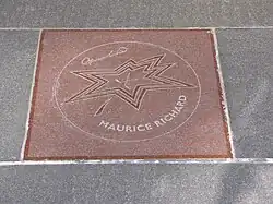 Photographie en couleur d'une plaque de commémoration avec un dessin d'étoile dessus