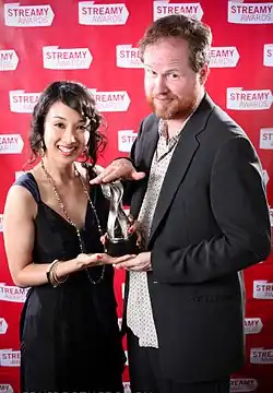 Maurissa Tancharoen et Joss Whedon tenant un trophée lors du gala des Streamy Awards.