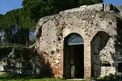 Photographie en couleurs d'un mur en maçonnerie percé d'une porte.
