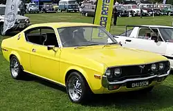 Une voiture de sport jaune en exposition à l'extérieur.