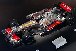 Photo d'une monoplace argentée et rouge en epxosition