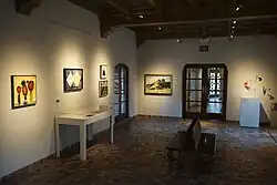 La galerie Peggy Pitman Mays au musée d'Art McNay , avec cinq tableaux et une sculpture exposés, et deux bancs au centre de la pièce.