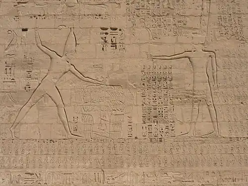  scène de combat, un homme porte un coup de massue à un autre homme à terre