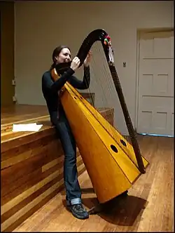 Jeune femme accordant une harpe andine.