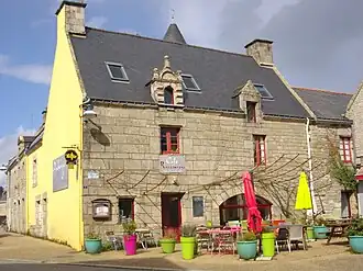 Maison ancienne avec lucarnes sculptées dans le bourg.