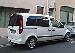 Photo d'une voiture blanche vue de trois-quart arrière dans une rue.