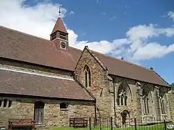 Photo en contre-plongée d'un bâtiment allongée au toit surplombé d'une tourelle munie d'une horloge