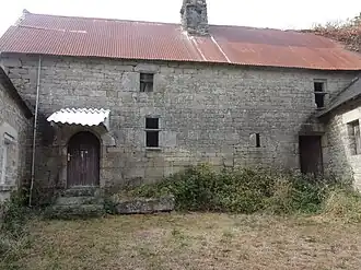 Vieille maison du village de Bonigeard ayant conservé ses linteaux sculptés et ses fenêtres à traverses.