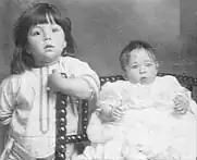 Bertram, debout à gauche à côté du bébé Millvina assis sur une chaise